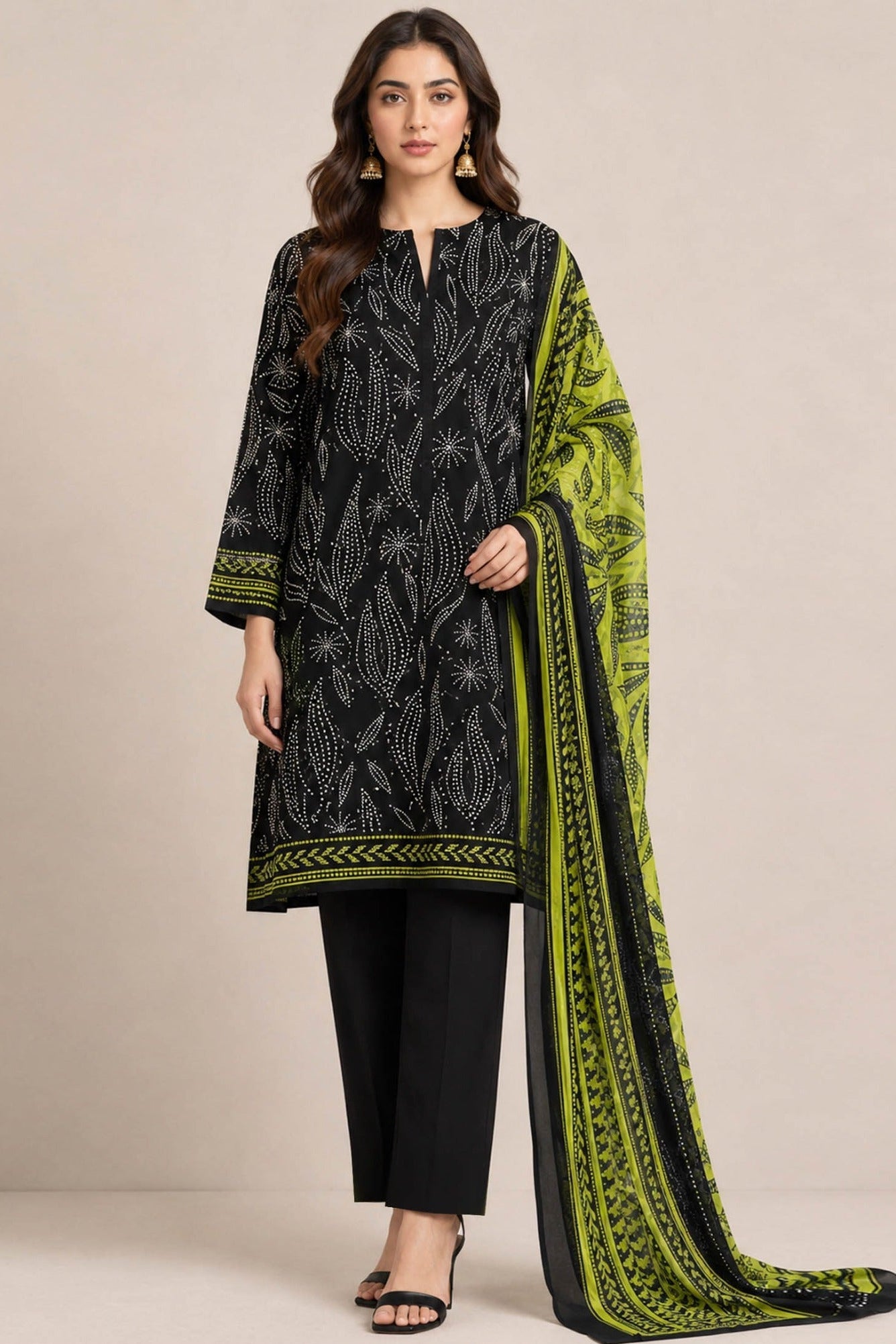 A fashion catalog composite showing a woman modeling a black printed kurta with a bright green and black patterned dupatta, alongside a smaller inset close-up of the dupatta on her head. Text on the right reads 'DESIGN STO CK' and lists the items as premium lawn shirt, chiffon dupata, plain trouser, with retail price 5590-/-.