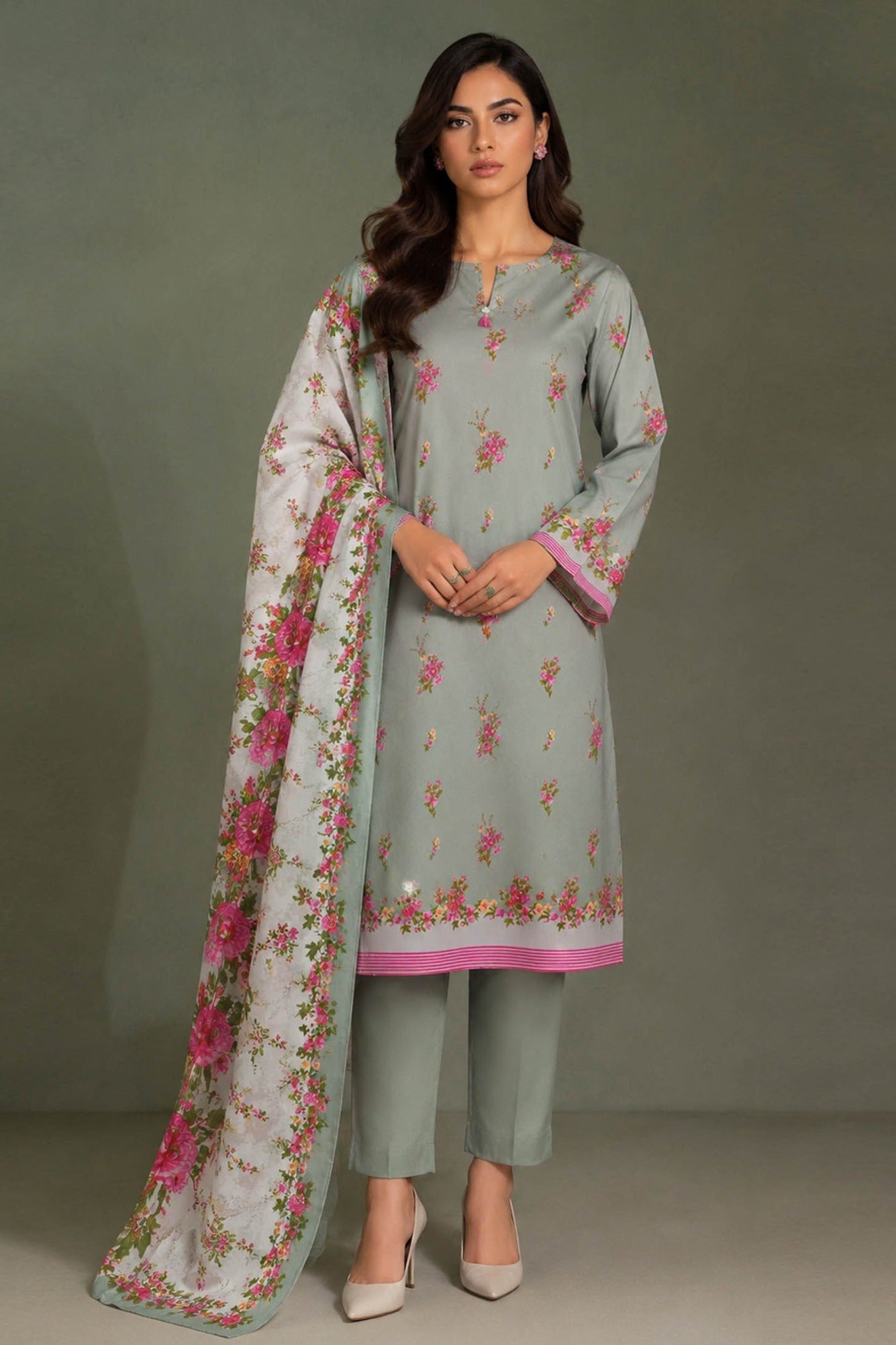 A three-panel catalog image showing a woman modeling a light gray floral salwar kameez suit with pink border details and a matching dupatta. The left panel shows the full outfit, the right panel shows a close-up, and the top-right panel contains product text including 'DESIGN STO CK' and 'Retail Price 5590-/-'.